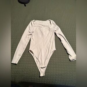 Cream colored long sleeve body suit